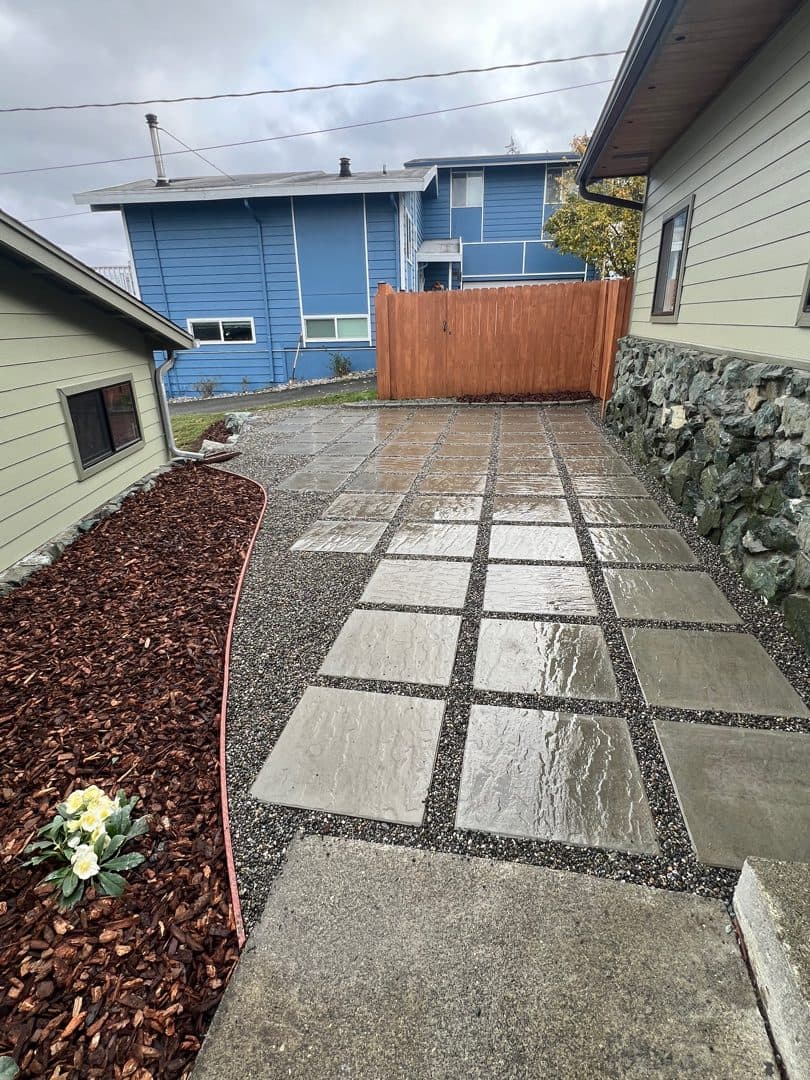 Reverse view of the Oak Harbor paver courtyard, showing the large slabs, gravel joints and mulched border