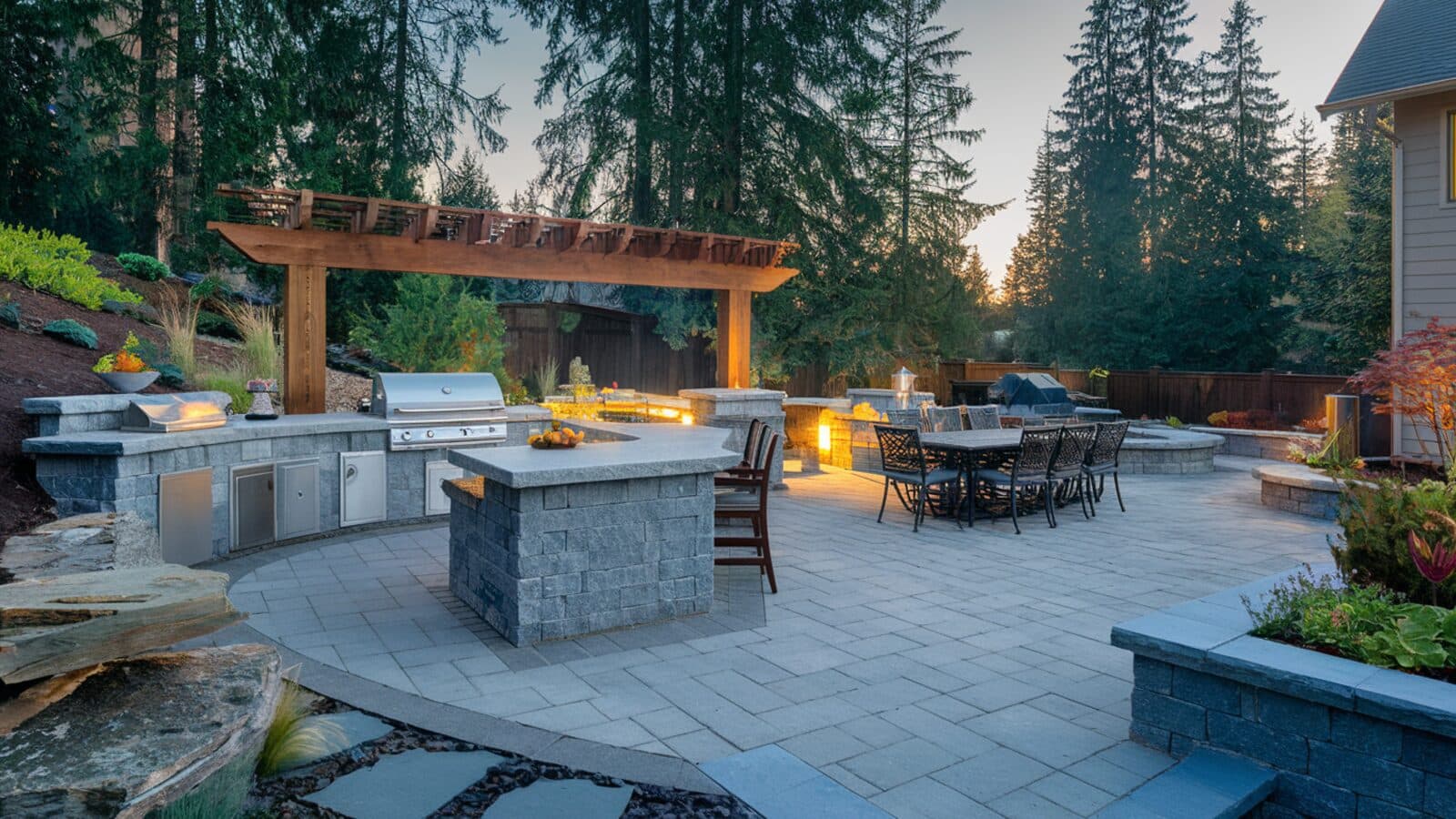 Luxury outdoor kitchen with built-in grill and stone patio